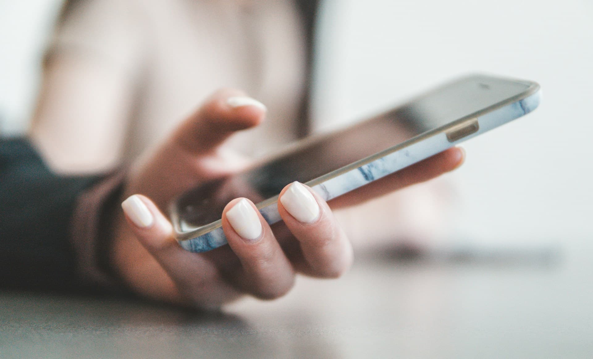 Person hält ein Smartphone zur digitalen Organisation von Kundenanfragen